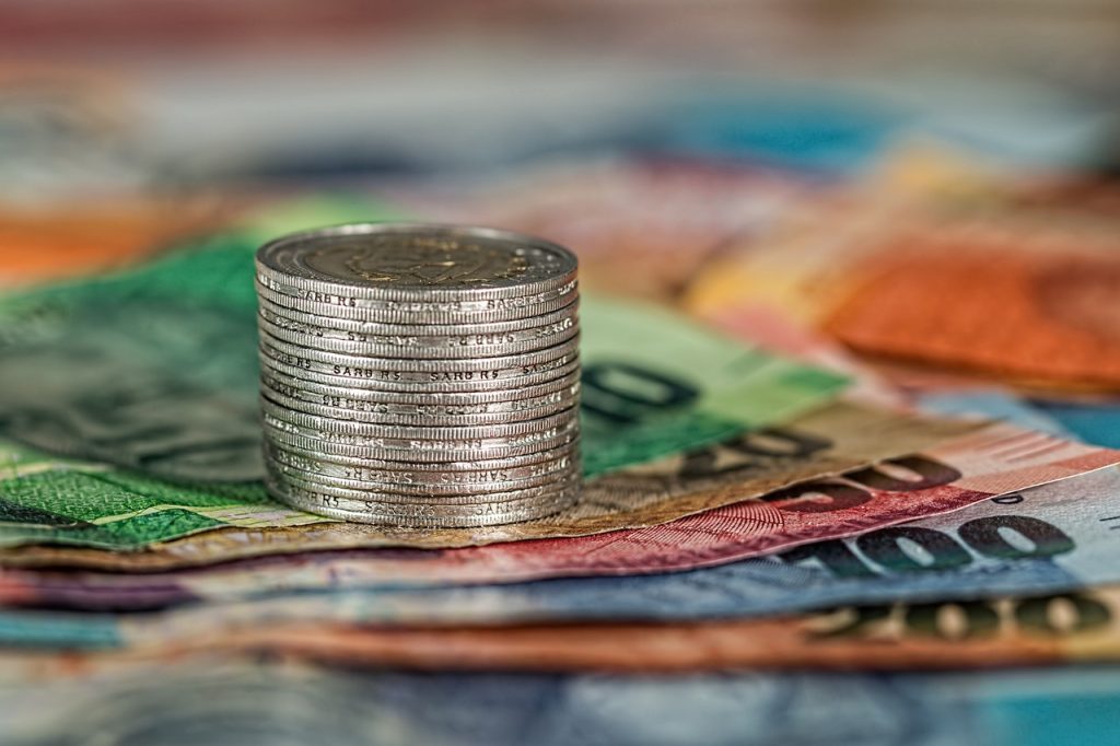 stack of bills alongside a stack of coins, symbolizing wealth and financial resources